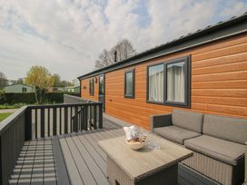 A deck area with seating and a table at Peony in Eardisland
