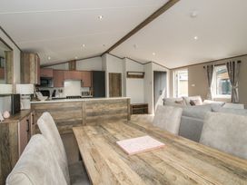 A dining area and kitchen with seating at Peony in Eardisland