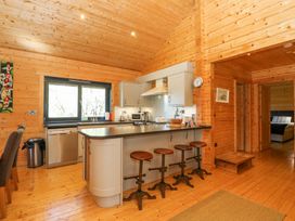 A kitchen with a countertop and four stools in a wooden cabin at Forsa Lodge in Glenforsa near Salen Isle Of Mull