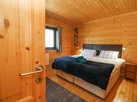 A bedroom with a double bed bedside tables and a window at Forsa Lodge in Glenforsa near Salen Isle Of Mull