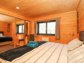 A bedroom with a bed pillows folded towels chair and mirrored closet doors at Forsa Lodge in Glenforsa near Salen Isle Of Mull