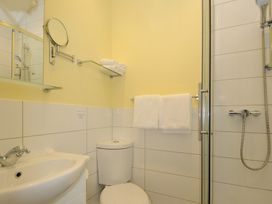 A bathroom with a sink a toilet a shower and towels at Sycamore Apartment in Lifton