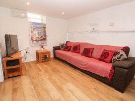 A living room with a sofa and television at 23 Carncrows Street St Ives