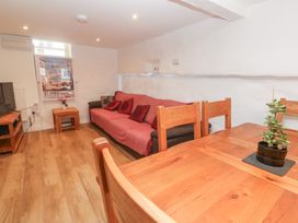 A living room with a sofa and dining table at 23 Carncrows Street St Ives