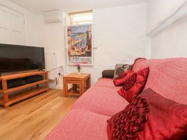 A living room with a sofa and television at 23 Carncrows Street St Ives