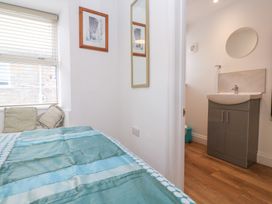 A bedroom with a bed and a sink area at 23 Carncrows Street St Ives