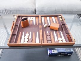 A backgammon board set up on a glass table in front of a white couch at Dolawen Bach in Conwy
