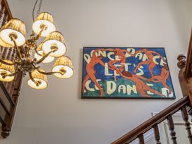 A staircase with a chandelier and wall art at Leathes Head Country House in Borrowdale near Keswick