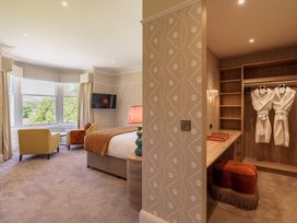 A bedroom with a bed and armchairs at Leathes Head Country House Borrowdale near Keswick