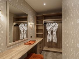 A dressing room with robes hanging and a mirror at Leathes Head Country House Borrowdale near Keswick