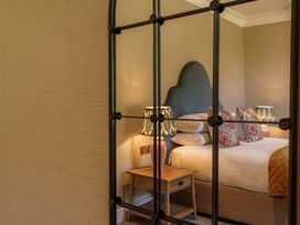 A bedroom with a bed, nightstand and lamps at Leathes Head Country House near Keswick