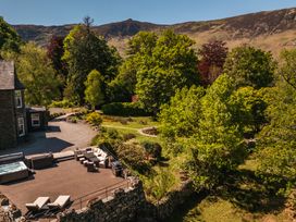 An outdoor seating area with a hot tub and trees at Leathes Head Country House, Borrowdale near Keswick