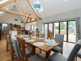 A dining room with a wooden table and chairs at Crossett Grange Driffield