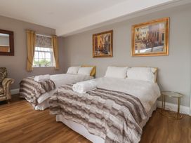 A bedroom with two beds and an armchair at Crossett Grange in Driffield