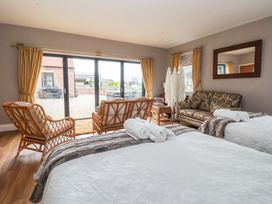 A bedroom with two beds and a sliding glass door at Crossett Grange Driffield