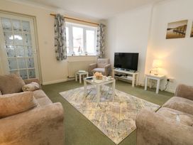 A living room with sofas a chair and a television at Dorset Explorers in Bournemouth
