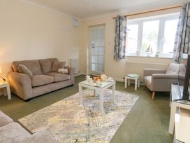 A living room with two sofas an armchair a coffee table with tea set and a patterned rug at Dorset Explorers in Bournemouth