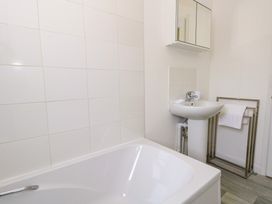 A bathroom with a bathtub sink wall-mounted mirror cabinet and a towel rack at Dorset Explorers in Bournemouth