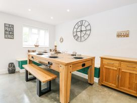 A dining room with a wooden table set with plates and glasses a bench a wooden sideboard and wall decorations at The Ivy in Happisburgh East Anglia