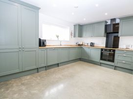 A kitchen with green cabinets wooden countertops and appliances at The Ivy in Happisburgh East Anglia