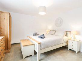 A bedroom with a double bed bedside tables lamps wardrobe and chest of drawers at The Ivy in Happisburgh East Anglia