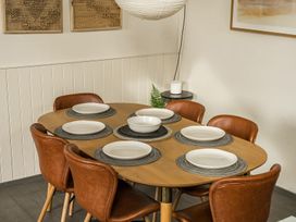 A dining table set with plates and chairs at Grove Cottage in Kington