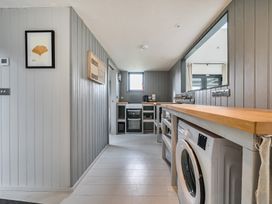 A utility room with a washing machine and a counter at Grove Cottage in Kington