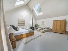 A bedroom with a wooden bed and chairs at Grove Cottage in Kington