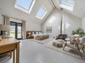 A bedroom with a bed, sofa, and stove at Grove Cottage in Kington