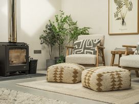A living room with a stove and armchairs at Grove Cottage in Kington