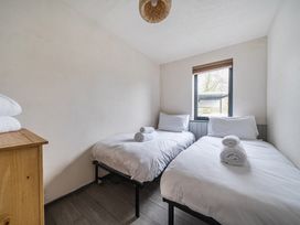 A bedroom with two beds and towels on a dresser at Grove Cottage in Kington