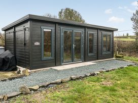 A cabin with large windows and pathway at Grove Cottage in Kington