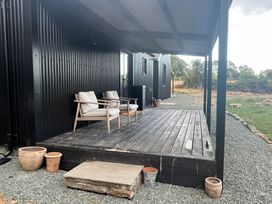 A deck with chairs and potted plants at Grove Cottage in Gladestry