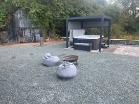 An outdoor area with a hot tub and seating at Grove Cottage in Gladestry