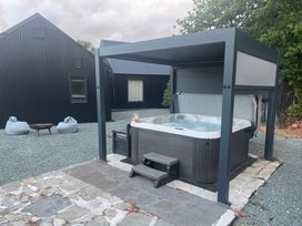 A hot tub under a pavilion in an outdoor area at Grove Cottage in Gladestry