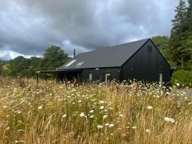 A house surrounded by grass and flowers at Grove Cottage in Gladestry