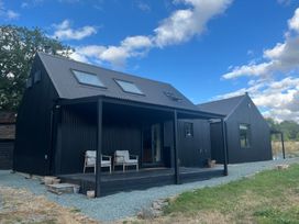 A house with a deck and chairs at Grove Cottage in Gladestry