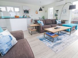 A living room with brown sofas blue cushions and a wooden coffee table on a blue patterned rug at Hepworth in Portreath
