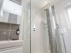 A bathroom with a sink cabinet and a shower enclosure with glass doors at Hepworth in Portreath
