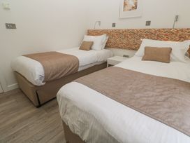 A bedroom with two single beds with beige throws and pillows and a patterned headboard at Hepworth in Portreath