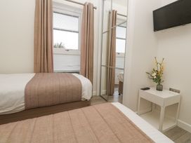 A bedroom with two single beds bedside table with flowers and a mounted TV at Hepworth in Portreath