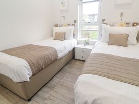 A bedroom with two single beds and a nightstand by a window at Hepworth in Portreath