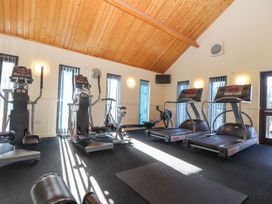 A gym room with treadmills ellipticals a stationary bike and exercise mats at Hepworth in Portreath