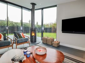 A living room with a wood stove and seating area at Harberton