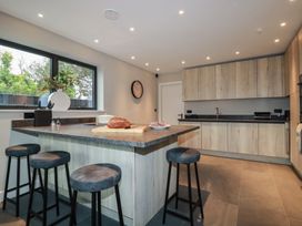 A kitchen with a counter and stools at Harberton in 