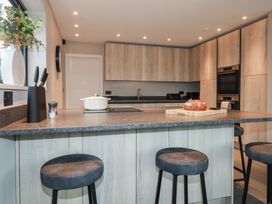 A kitchen with bar stools and cooking utensils at Harberton, 