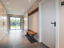 A hallway with a bench and sliding glass door at Harberton