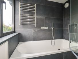 A bathroom featuring a bathtub, towel rail, and shower at Harberton