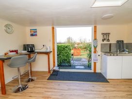A kitchenette with two chairs at a counter and a small kitchen area with a sink and utensils at Shed Your Blues Brilley near Kington