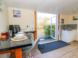 A kitchen area with a countertop set with plates bowls and glasses near an open door leading outside at Shed Your Blues Brilley near Kington
